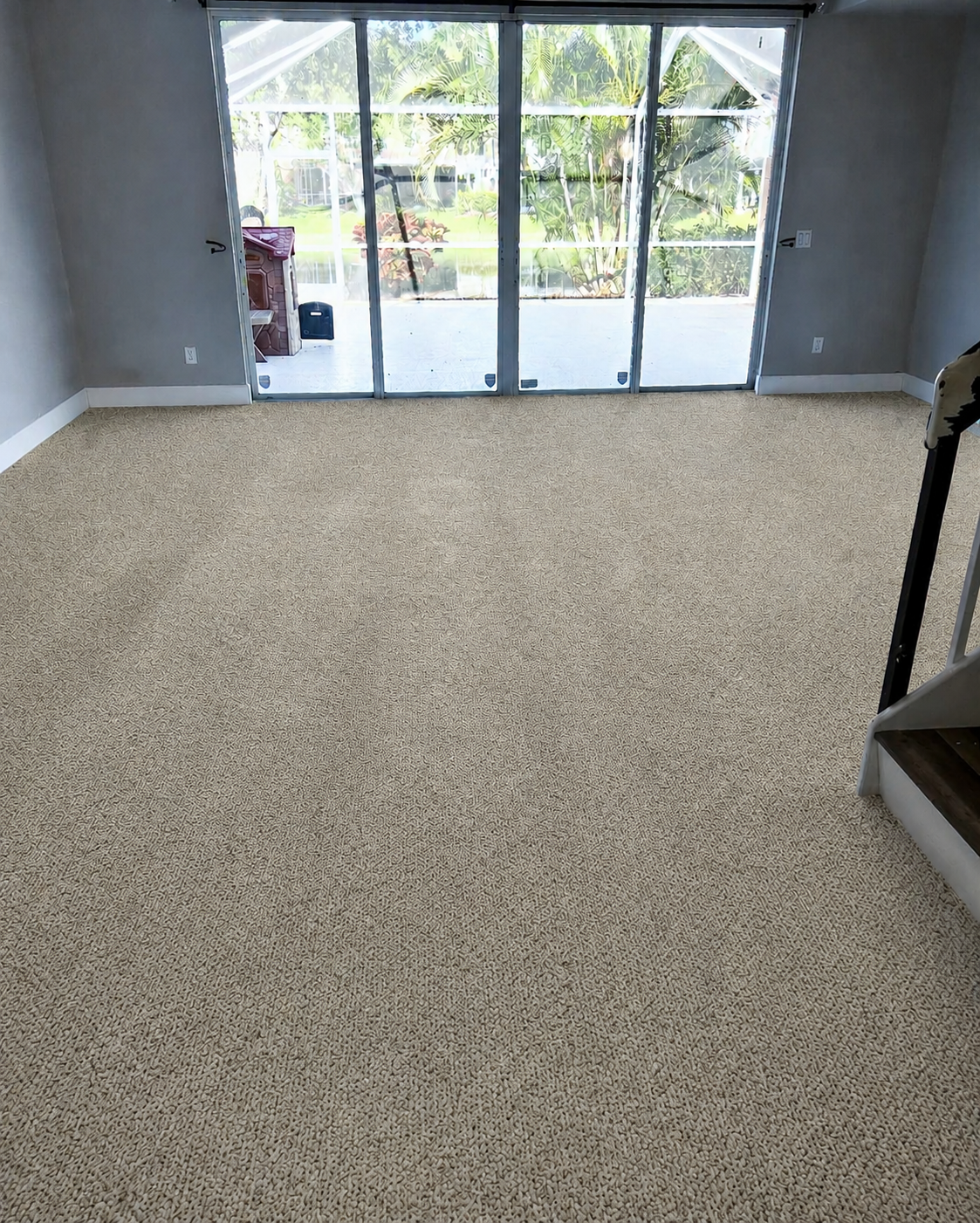 Worn beige carpet in a living room before tile replacement